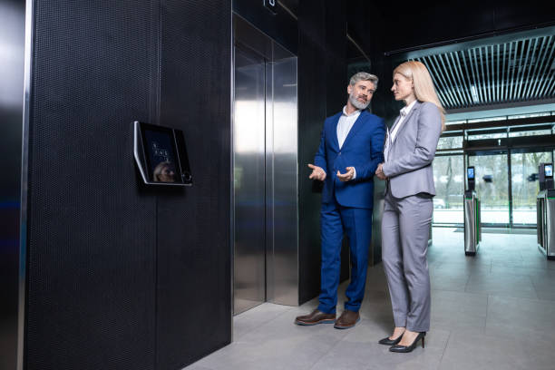 istock Two colleagues talking while waiting for the elevator in a business center 2202846917