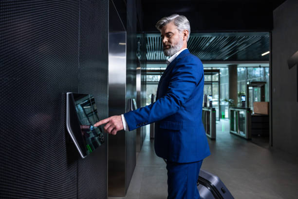 istock Gray-haired elegant businessman pressing the button to call the elevator 2202846950