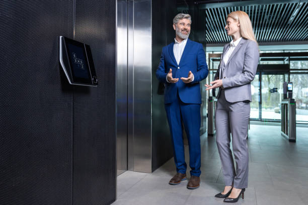 istock Two colleagues talking while waiting for the elevator in a business center 2202846953