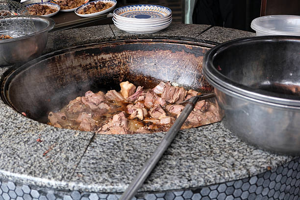 istock Steaming meat cooking slowly in a traditional pot over an open flame during a local culinary event 2202852408