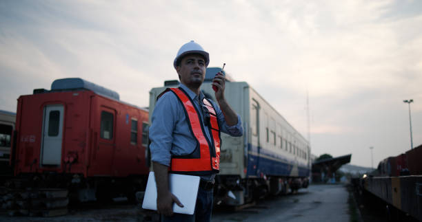 Middle male logistic  engineer checking safety or quality control on the freight train in container cargo warehouse for carrier container and distribution to worldwide.