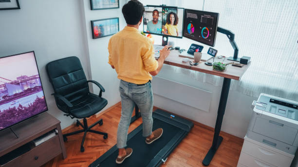 istock Man at standing desk home office talking on business video call 2202854271