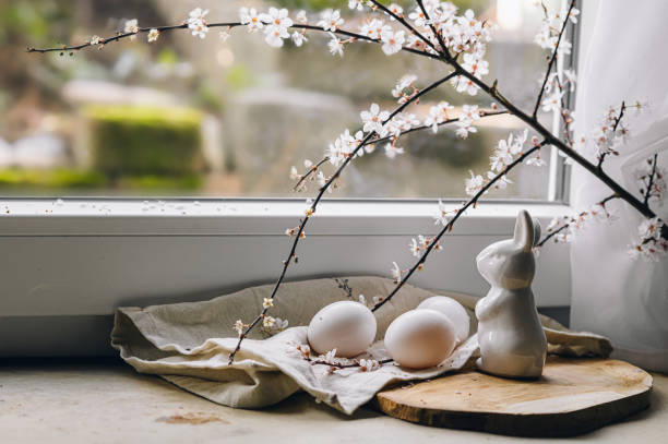 istock Beautiful branches lie on a wooden board on the windowsill. Composition with Easter eggs and bunny. Spring greeting background with place for text. 2202855106