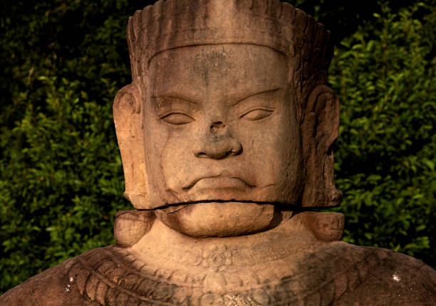 stone idol in yellow cloth on the territory of the Angkor Wat temple complex