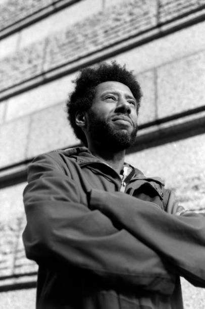 istock Pensive afro-american man looking up with folded arms in monochrome 2202861327
