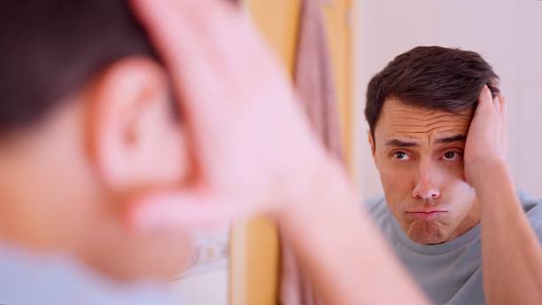 istock Narcissistic man admiring himself in bathroom mirror 2202861657