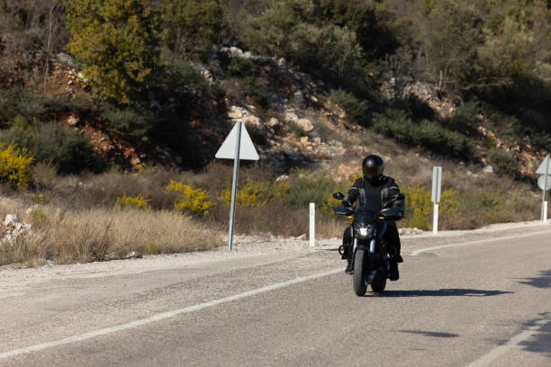 istock An man riding a motorcycle on a long road 2202864487