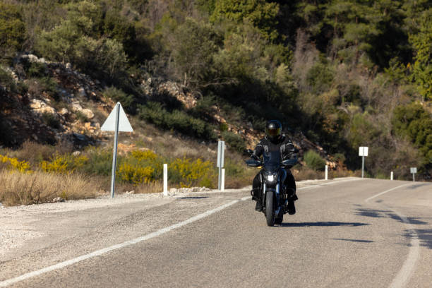 istock An man riding a motorcycle on a long road 2202864579
