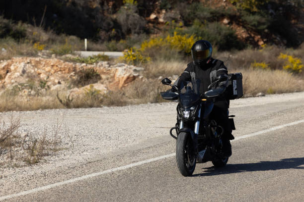 istock An man riding a motorcycle on a long road 2202864580