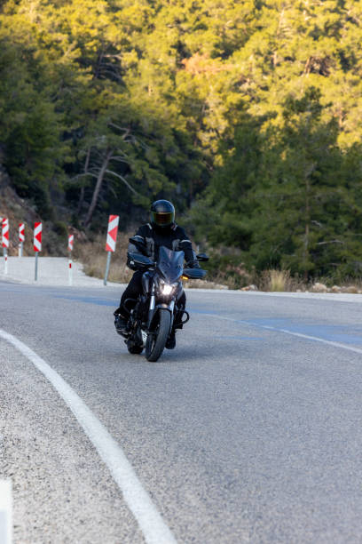 istock An man riding a motorcycle on a long road 2202865280