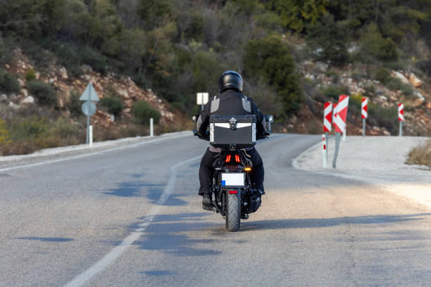 istock An man riding a motorcycle on a long road 2202865282