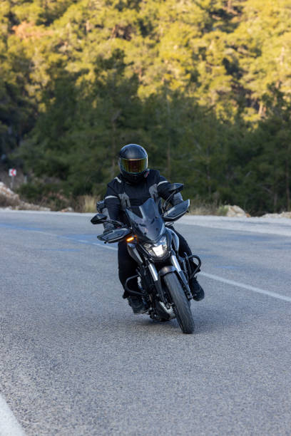 istock An man riding a motorcycle on a long road 2202865379