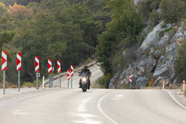 An man riding a motorcycle on a long road