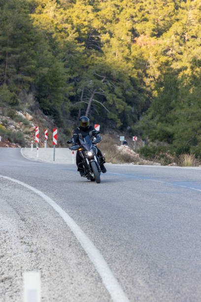 istock An man riding a motorcycle on a long road 2202865381