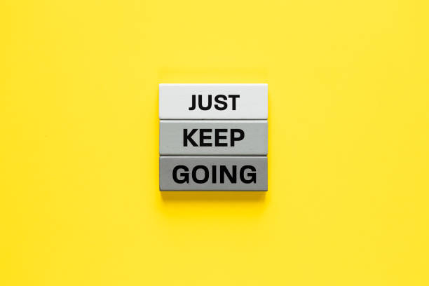 istock Just Keep Going. Slogan on wooden blocks. Motivational words, Company support, Modern methods of managing people. Yellow background. copy space 2202865539