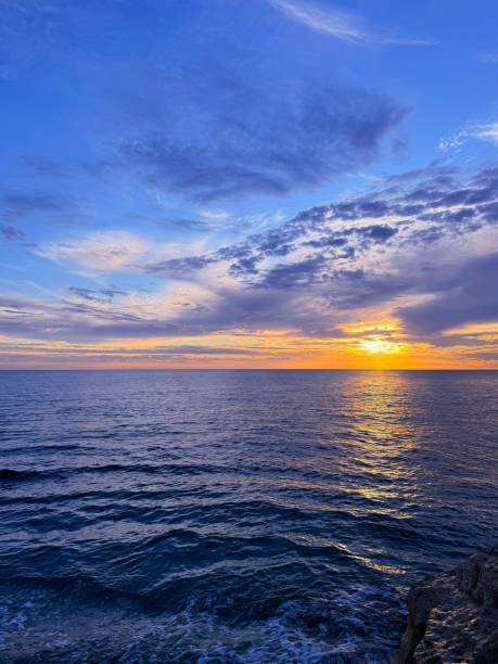 istock Sea waves and sunset sky clouds 2202866425
