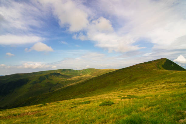 Rakhiv district, Ukraine - August 22, 2020: Groups of tourists walk along a path on a mountain range in the Carpathians.
