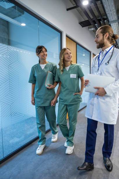 istock Healthcare team moving through spacious hospital corridor preparing for their next shift while having casual conversation 2202869104