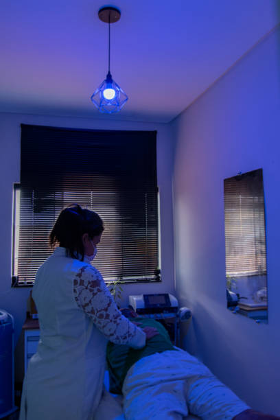 man performing aesthetic procedure in clinic with LED neon light