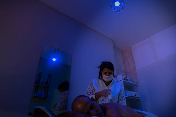 man performing aesthetic procedure in clinic with LED neon light