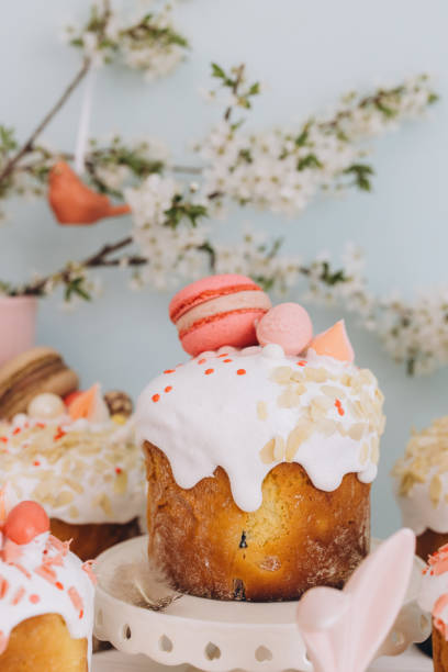 istock Delicious easter cakes with white icing, macarons and almond flakes decorating a festive table 2202872021