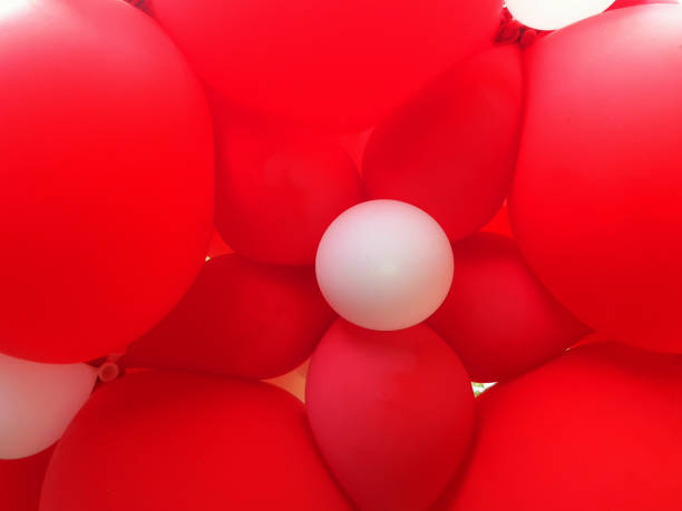 istock Red and white balloons background. Plastic texture. Parties and celebrations. Full frame latex balloons. 2202874294