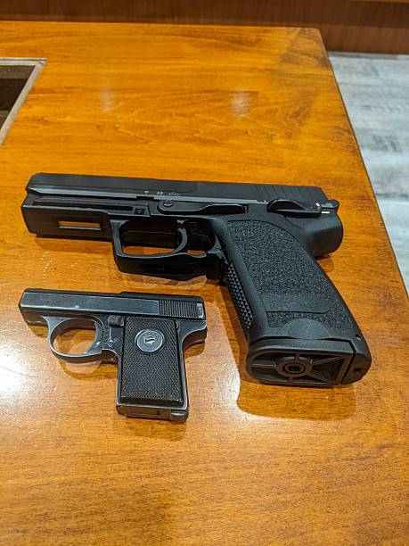istock Close-Up of Two Handguns Displayed on a Wooden Surface 2202874912