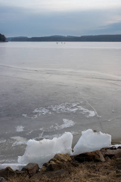 Pond (dam) Lipno, when its frozen and its too small for the ice, which is on the coast breaking. Mountains in the background. Horni Plana, Czech repbulic.