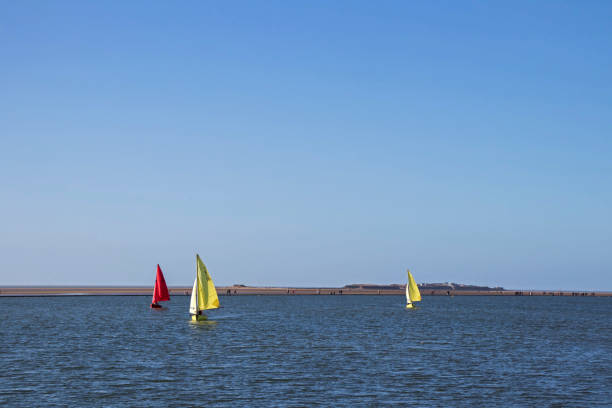 View across marine lake in West Kirby, Wirral, UK.  People can be seen walking on a footpath around the lake and on sailing boats