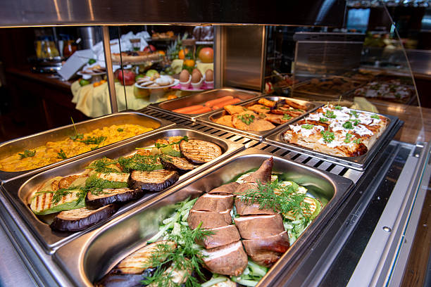 istock Buffet display of assorted food items including cooked meat grilled vegetables and other dishes in stainless steel trays Tasty! 2202884735