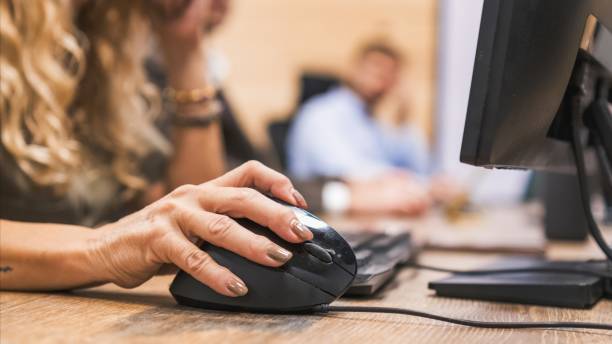 istock Crop mature businesswoman using computer mouse on desk in office 2202892627