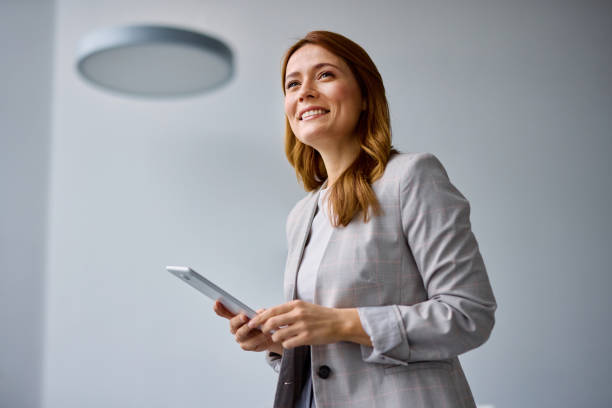 Smiling businesswoman using digital tablet in modern office