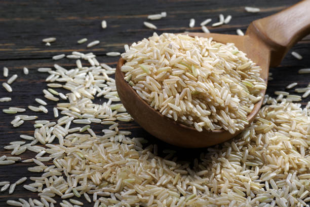 istock brown rice in a spoon on a wooden table 2202901089