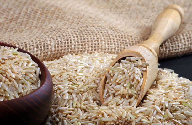 istock brown rice in a scoop on a table. close up 2202901097