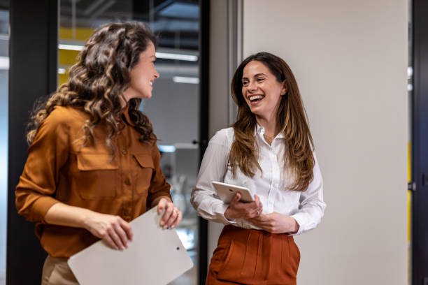 istock Two businesswomen smiling and collaborating in modern office 2202906265
