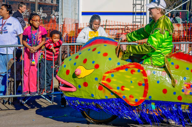 Mobile, Alabama, USA - Feb. 7, 2016: Children look at a fish-shaped Mardi Gras float mounted on a bicycle during the Joe Cain Day Mardi Gras parade in Mobile, Alabama.
