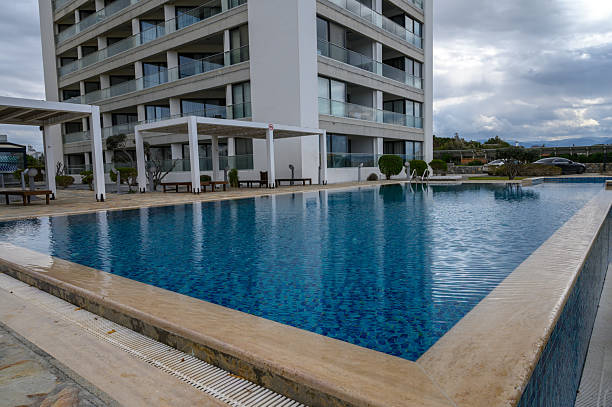 istock Elegant swimming pool surrounded by modern architecture on a cloudy day 2202915581