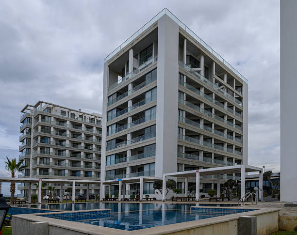 istock Modern beachfront apartments under cloudy skies overlooking a tranquil pool area 2202915596