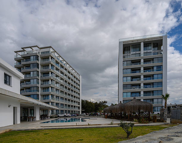 istock Modern resort buildings under a cloudy sky with a serene poolside view in a tranquil vacation destination 2202915602