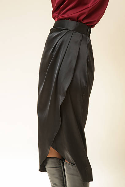 istock Female model wearing midi black silk skirt, studio shot 2202918142