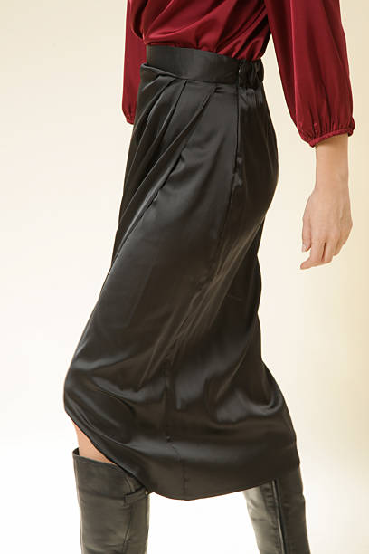 istock Female model wearing midi black silk skirt, studio shot 2202918182
