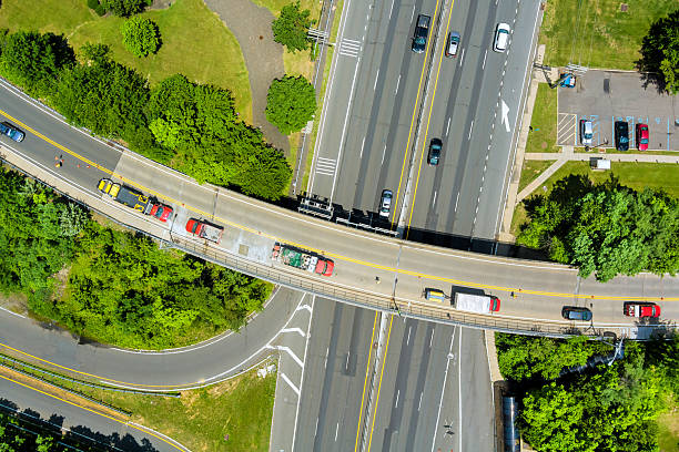 istock Traffic flows along a busy road intersection surrounded by greenery in a suburban area during daytime 2202918866