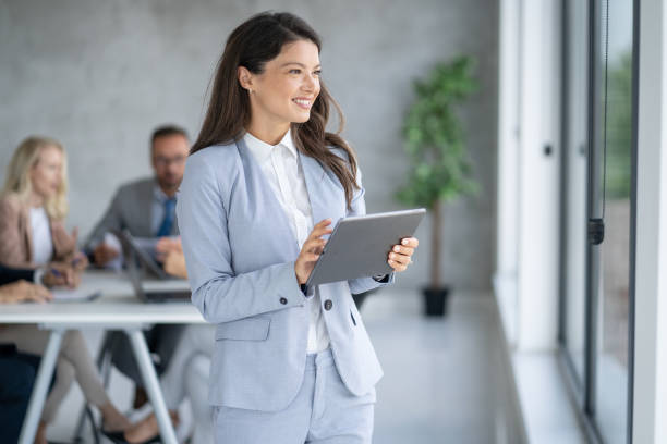 istock Professional Woman Smiling with Tablet in a Bright Office 2202920492