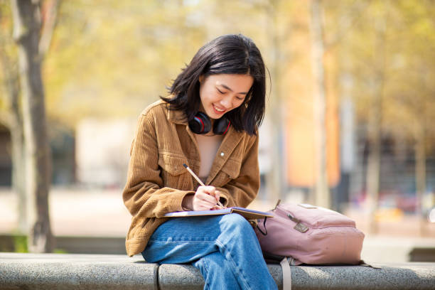 istock young woman sitting with pen and book 2202920857