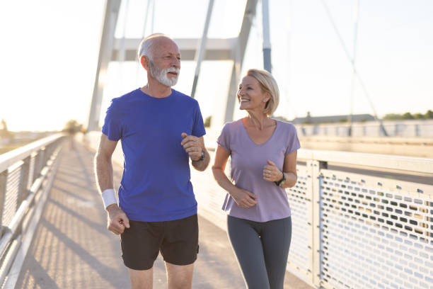 istock Elderly couple enjoying a run together on a bridge with bright smiles 2202933457