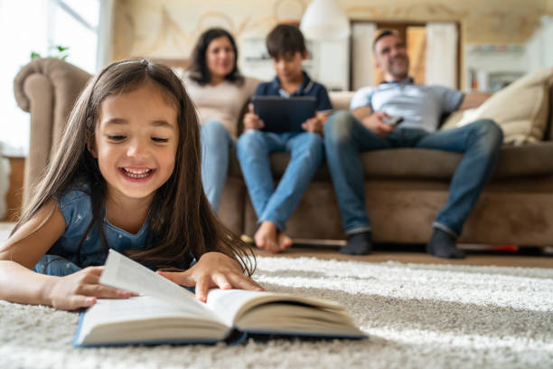 istock Small girl reading a book on the floor 2202933679