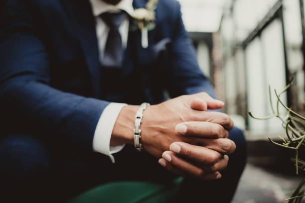African American man in suit and necktie sitting with hands clasped