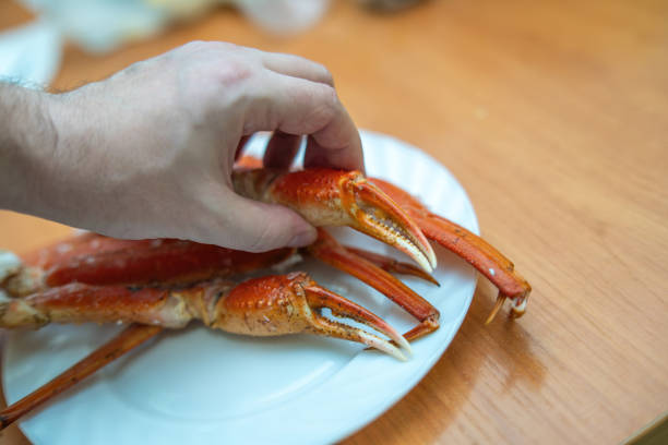 istock hand reaches into a segment claw of a boiled crab, pulling out a large piece of succulent crab meat, showcasing the delicious seafood delicacy 2202934261