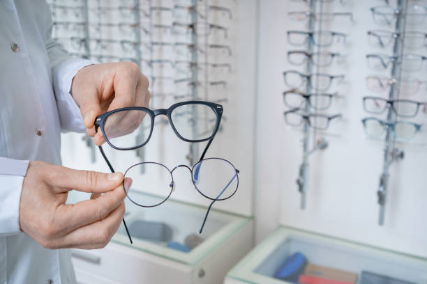 istock Optic shop assistant showing eyeglasses to a client in a optic shop 2202935772