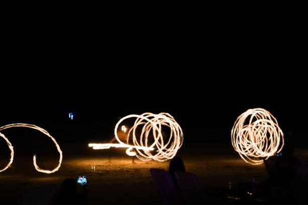 istock Artist fire juggling performance on the beach. 2202950404